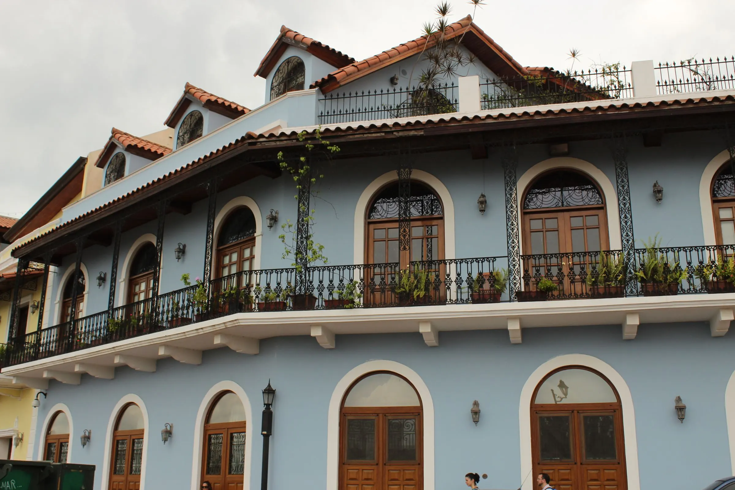 Edificio colonial con ventanas en arco y un balcón largo.