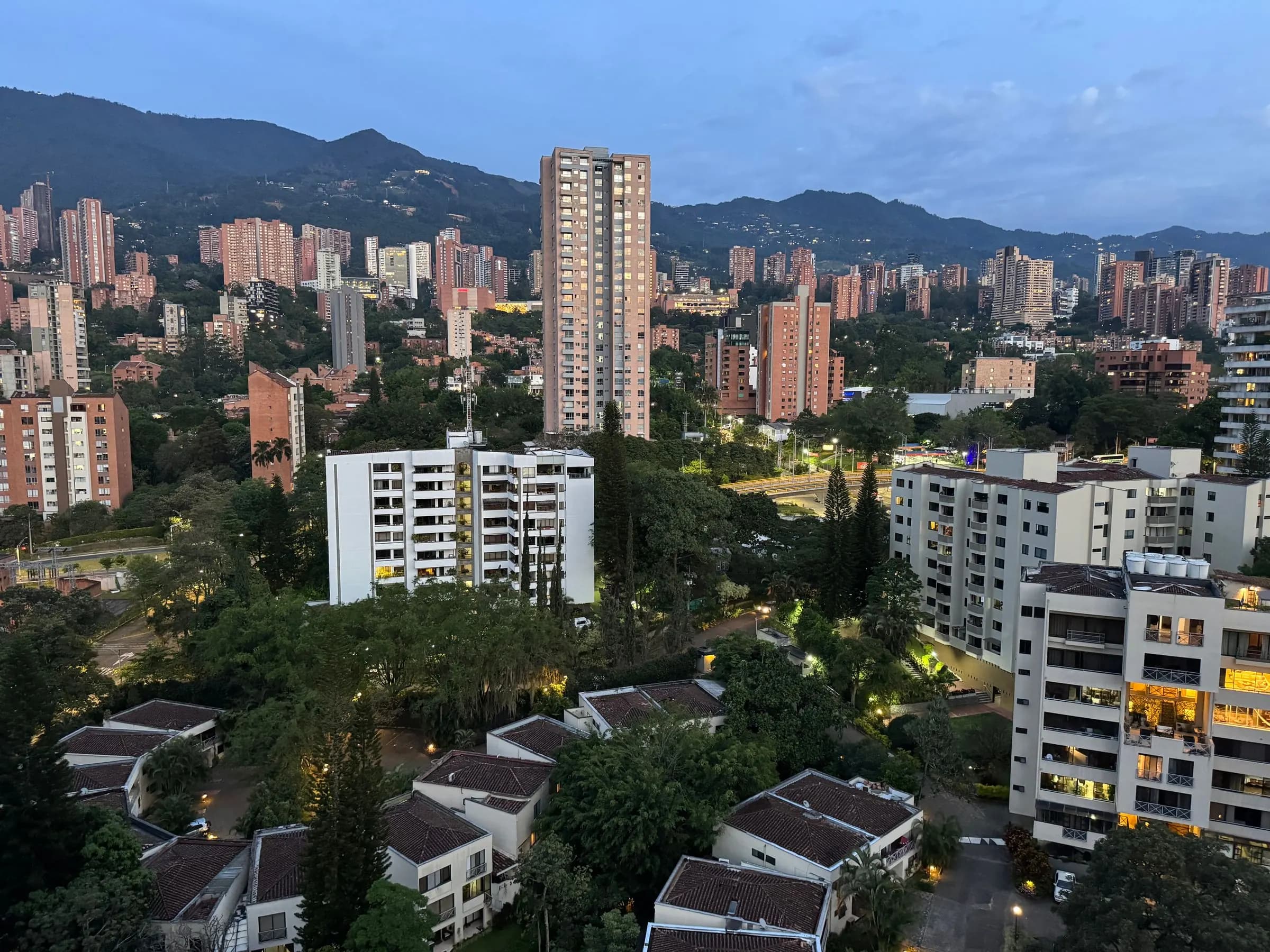 Torres residenciales entre árboles con luz de la mañana.